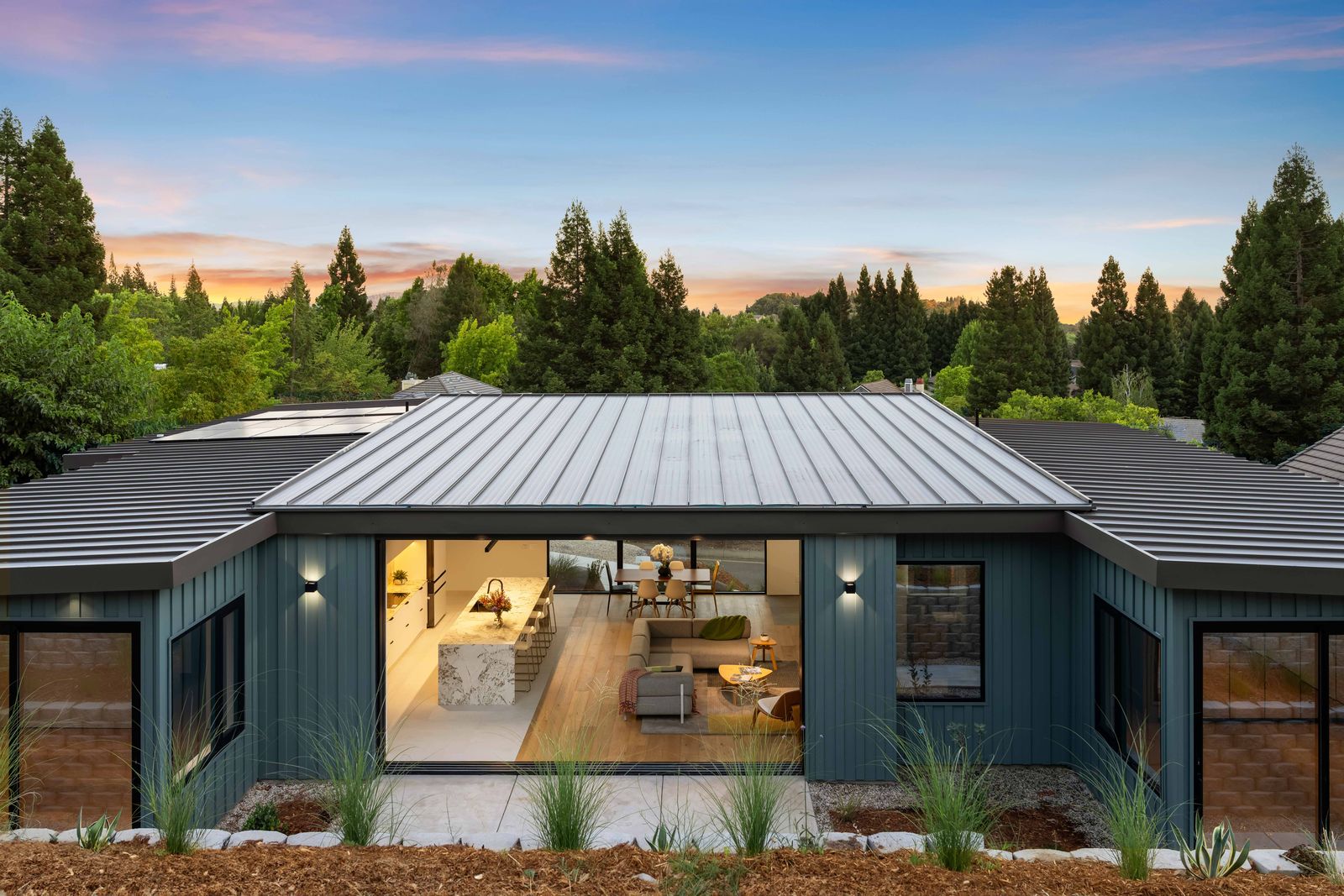 Rear elevation with standing-seam roof and treetop backdrop