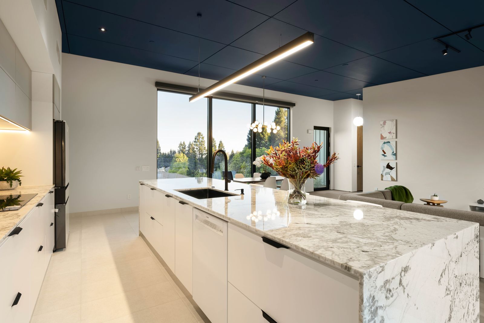 Kitchen with marble waterfall island and navy ceiling