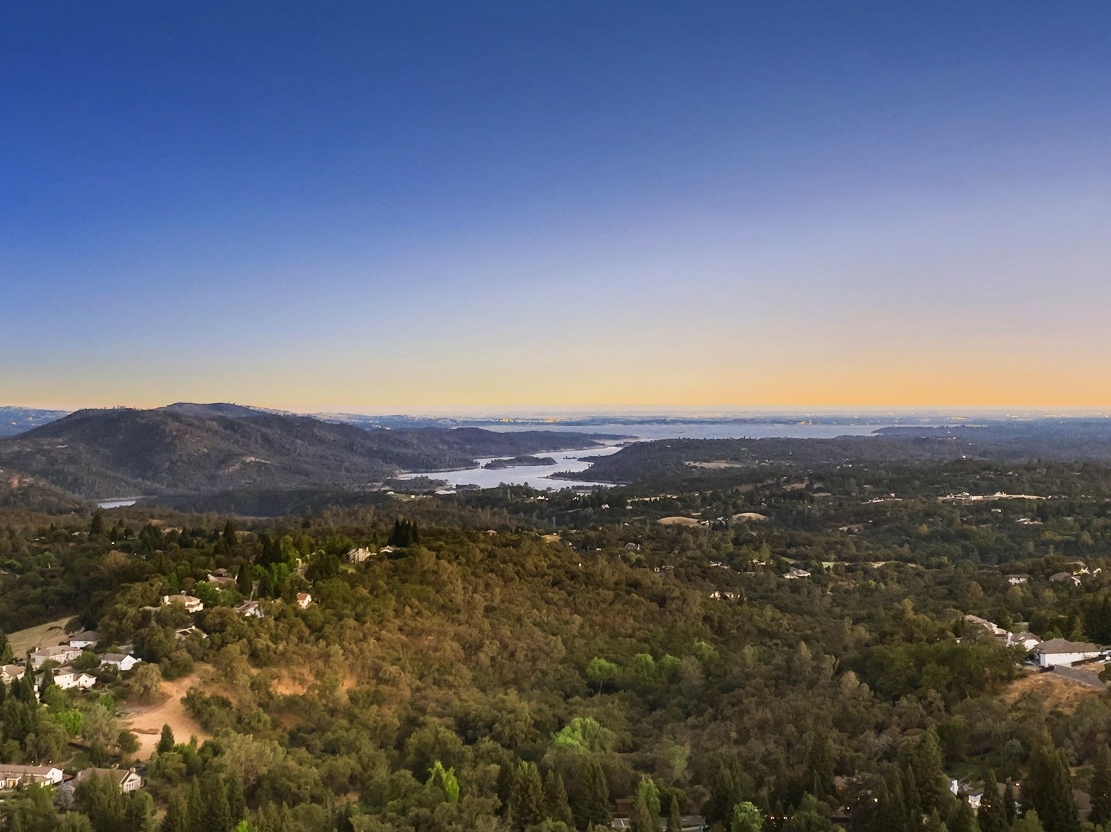Aerial view of the valley and reservoir at dusk from the property